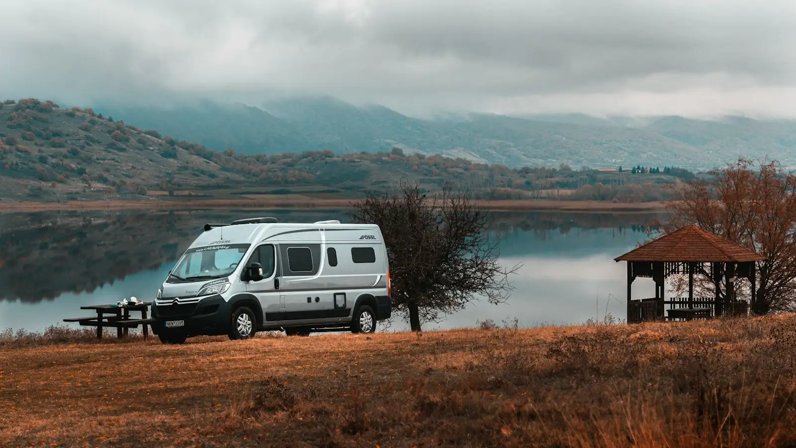 Un van aménagé garé au bord d’un lac de montagne
