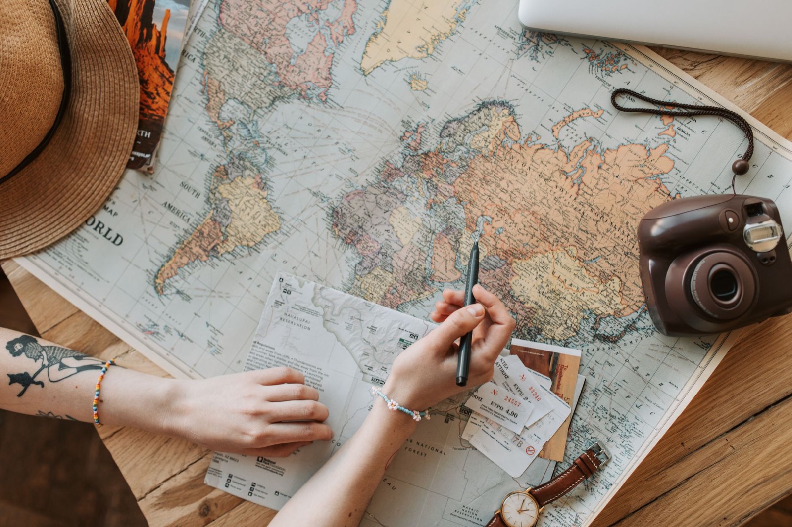 Voyageuse préparant un séjour avec un ordinateur portable, une carte et un passeport
