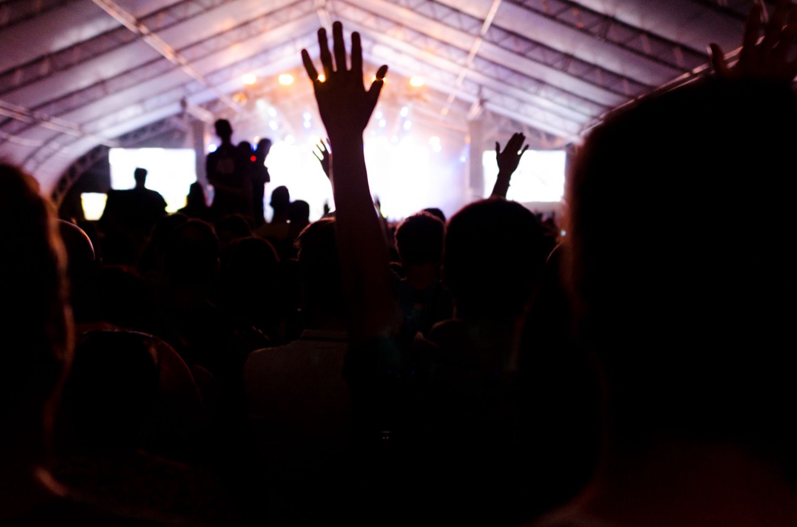 Silhouette de la foule devant la scène d'un festival de musique en soirée