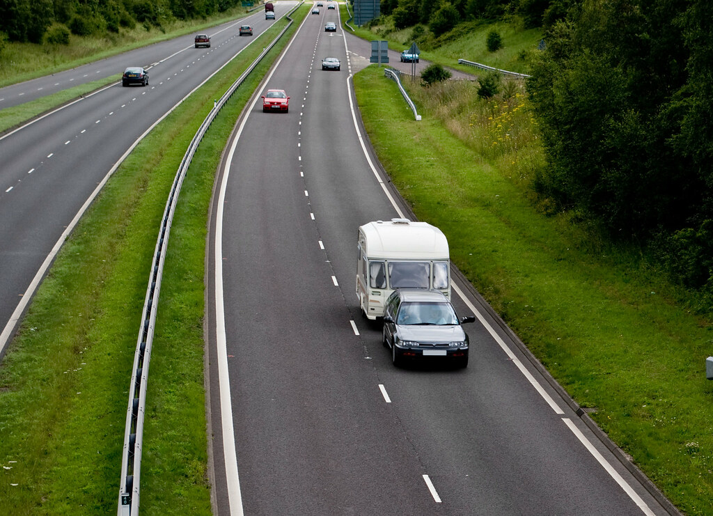 Voiture tractant une caravane sur une voie rapide, le poids total en jeu